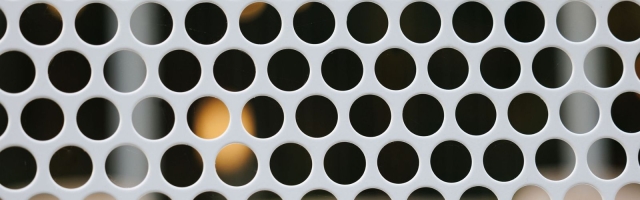 a close up of a circle pattern on perforated metal