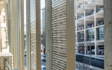 Looking at perforated metal from a parking Garage