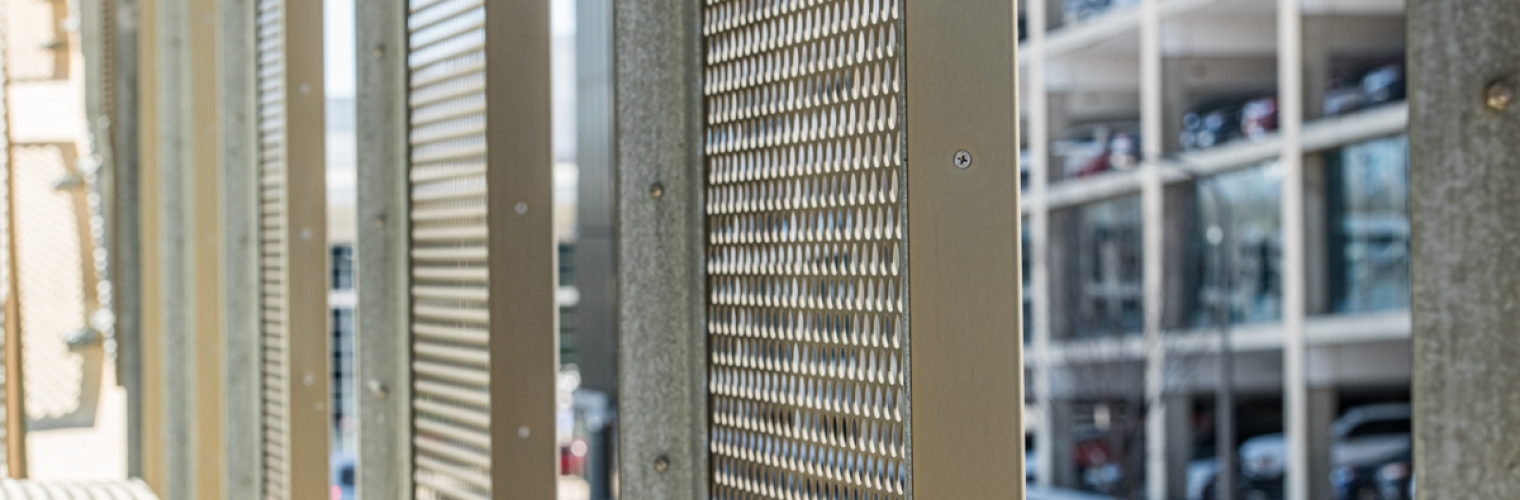 Looking at perforated metal from a parking Garage